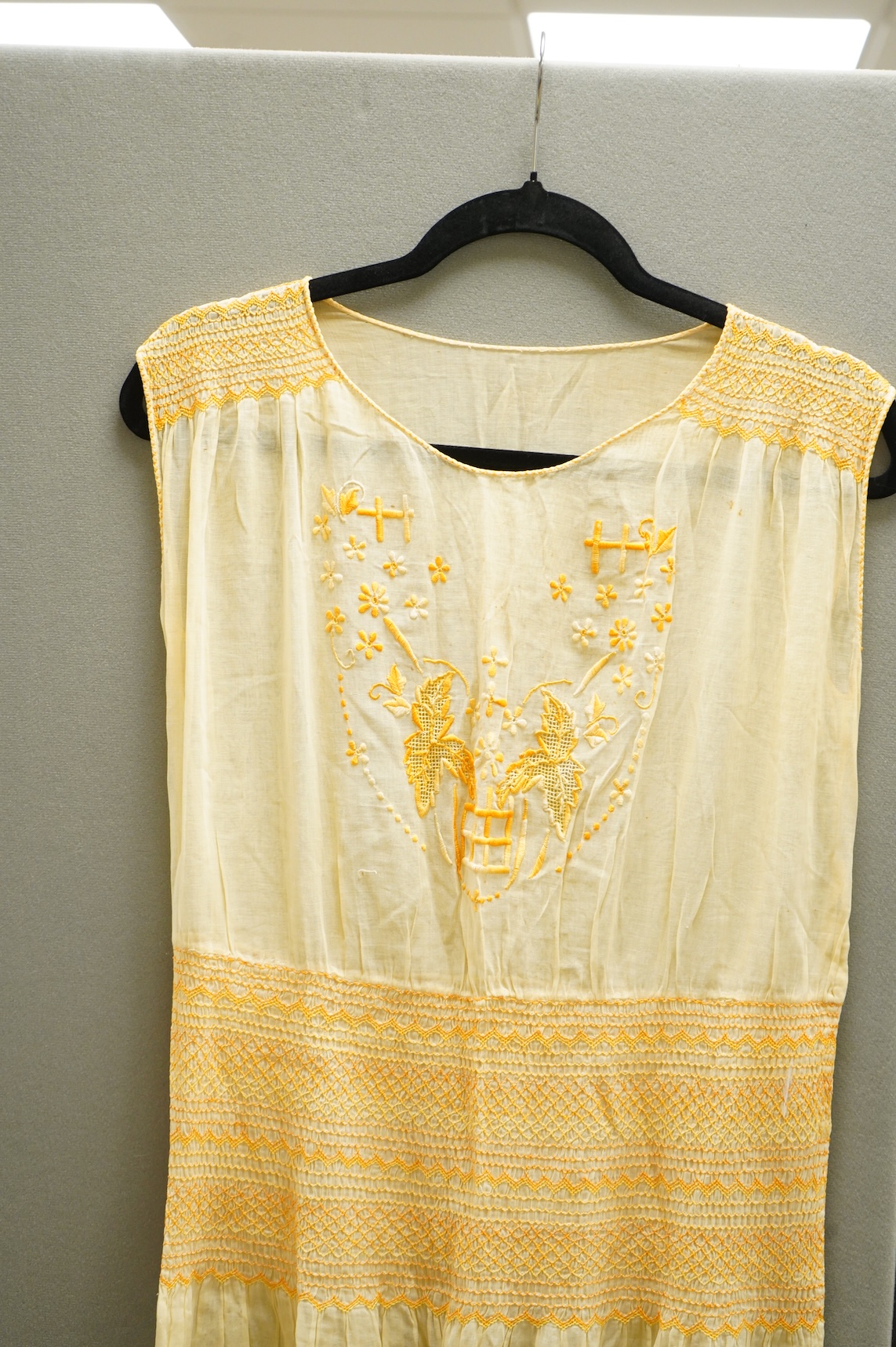 A 1920-30's fine yellow cotton gauze, embroidered and smocked day dress. 117cm long. Condition - good